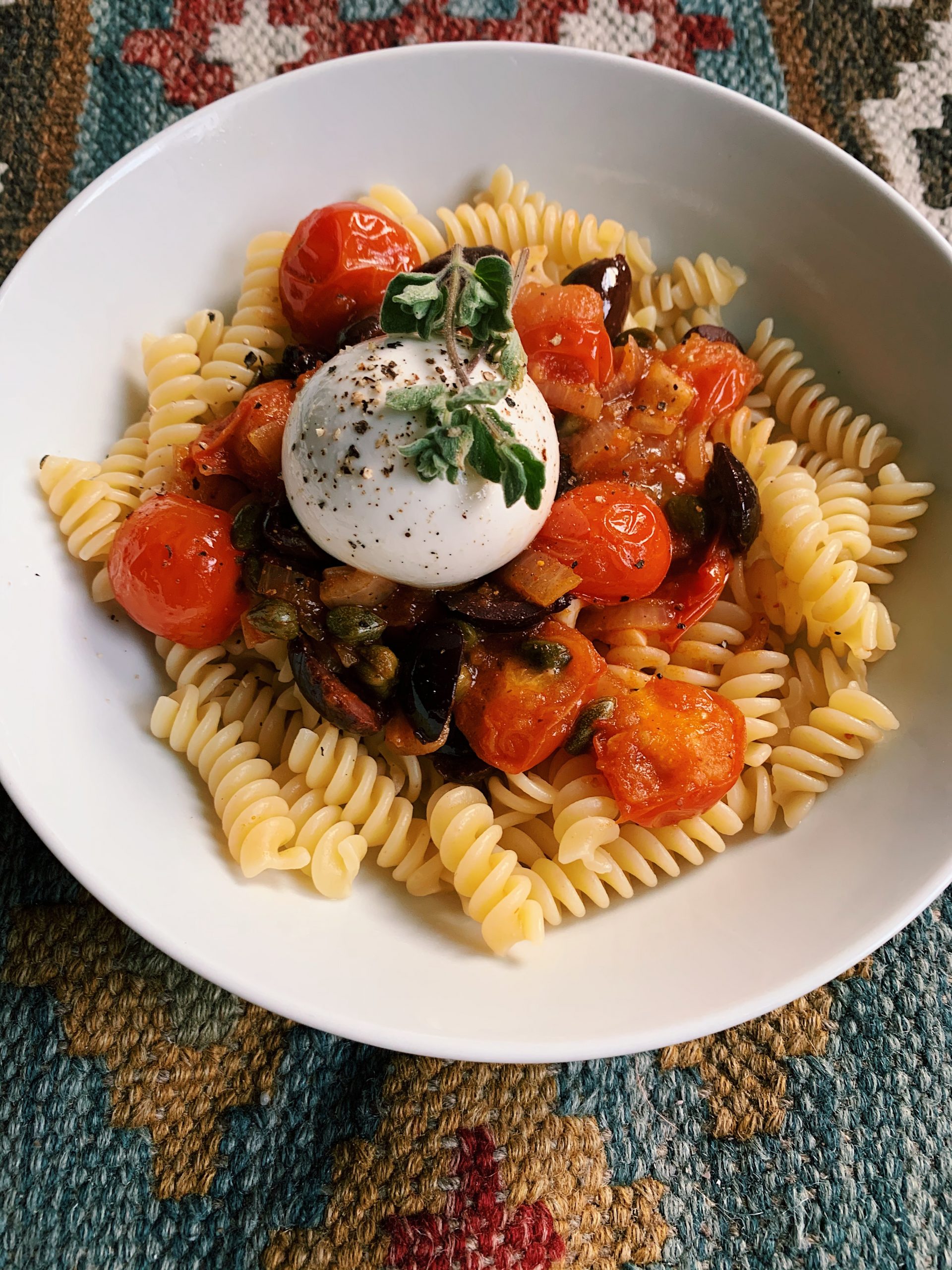 Pasta met burrata, harissa, olijven en cherrytomaatjes