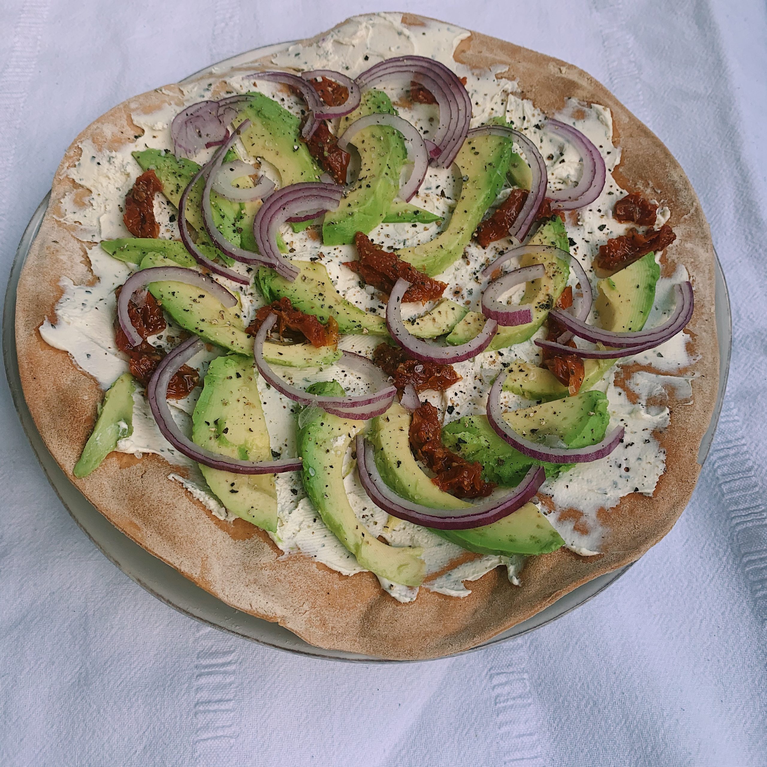 Flammkuchen met avocado, ui en zongedroogde tomaten