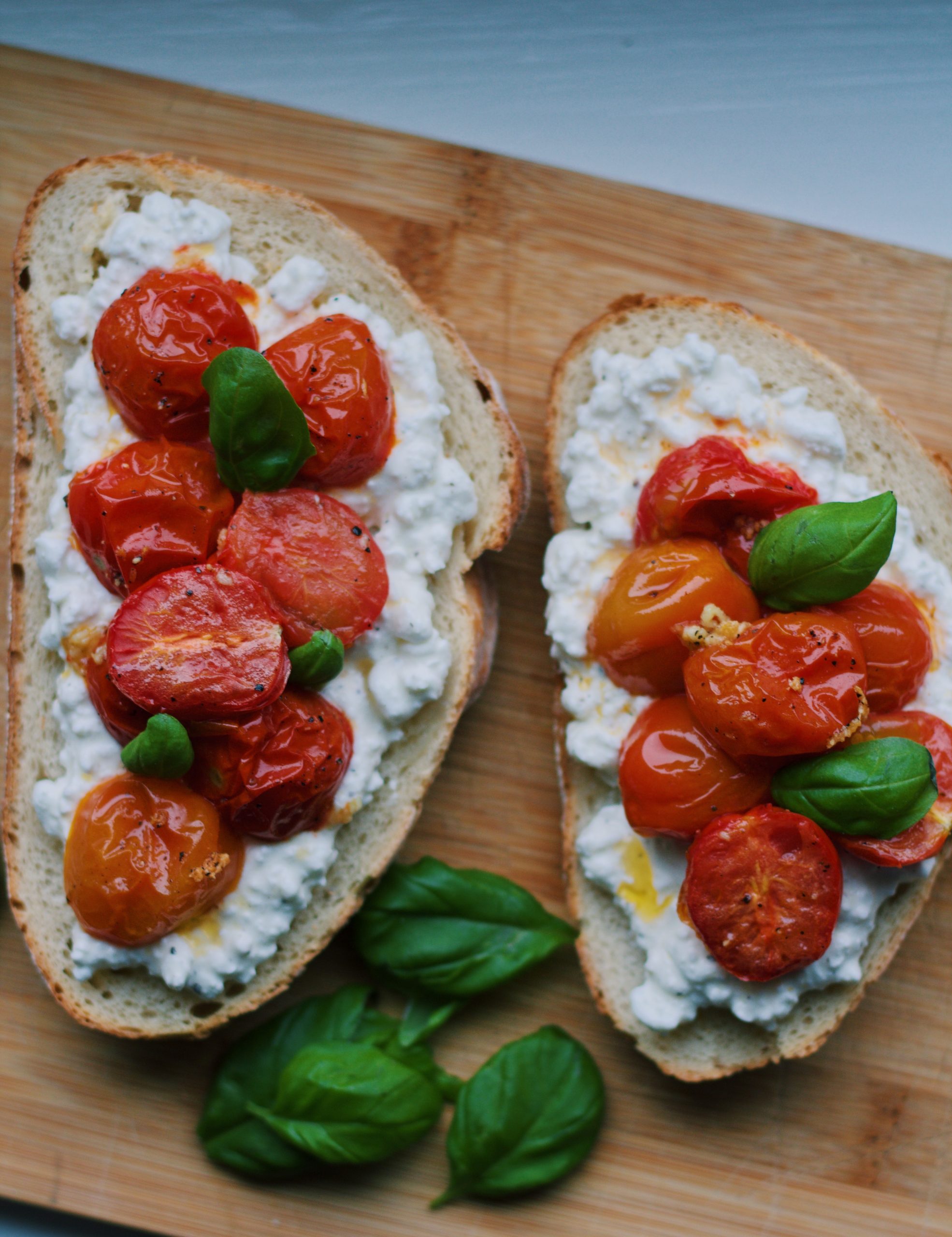 Toast met hüttenkase, geroosterde cherrytomaatjes en bassilicum