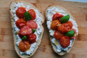 Toast met hüttenkase, geroosterde cherrytomaatjes en bassilicum